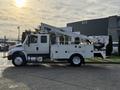 A 2013 International Durastar 4300 truck with a mounted articulated boom lift and utility service body