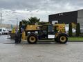 A 2014 Caterpillar TL1055C telehandler with a yellow and black exterior equipped with a front fork attachment