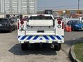 A 2017 Chevrolet Colorado with a white and blue rear design and a truck bed cover parked at an industrial location
