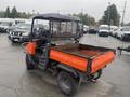 2010 Kubota RTV 900 utility vehicle features an orange cargo bed and a black cab with a transparent roof designed for transporting goods and equipment