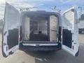 A white 2017 Ford Transit van with double rear doors open revealing an empty interior with wooden shelves and storage compartments