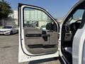A white 2019 Ford F-150 with an open driver's side door showcasing the interior features and door panel design