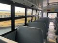 Interior view of a 2007 Freightliner B2 school bus with gray seats arranged in rows along the aisle leading to the front of the bus