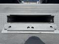 A metal ramp on a truck with a textured surface and a rectangular opening for loading items onto a 2011 Ford F-550