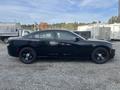 A black 2015 Dodge Charger seen from the side with a sleek profile and black wheels