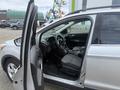2014 Ford Escape with an open driver's door showing the interior including seats steering wheel and dashboard