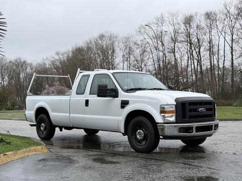A white 2008 Ford F-250 SD pickup truck with a cab and open bed, featuring black wheels and a metal ladder rack attached to the bed