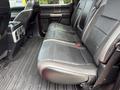 A 2019 Ford F-150 with black leather seats in the back row and a flat floor design featuring cup holders and controls in the center console