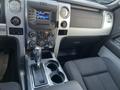 Interior view of a 2014 Ford F-150 showing the center console with a gear shifter audio system and dual cup holders