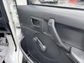 The interior door of a 2008 Suzuki Carry featuring a manual window crank and a simple door handle