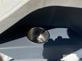 A stainless steel cup holder set into a blue surface of a 2013 Larson 238 boat