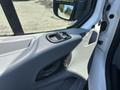 Close-up of the driver side door panel of a 2019 Ford Transit 350 featuring a handle control buttons and armrest detailing