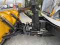A 2016 International 7600 featuring a snowplow attachment with hydraulic components and a black frame