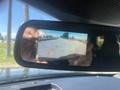 A 2020 Ford Explorer dashboard rearview mirror displaying a backup camera view with guidelines for parking