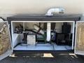 A 2008 Peterbilt 340 maintenance compartment showing plumbing and mechanical components including pumps hoses and a motor