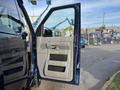A 2013 Ford E-350 Super Duty with an open driver's side door revealing the interior panel and handle