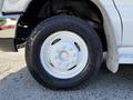 A white Ford Econoline van with a visible tire featuring a tread pattern and a hubcap