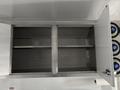 An empty stainless steel cabinet with two shelves and an open door revealing no contents inside