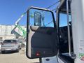 A 2020 Peterbilt 330 truck with an open driver's side door displaying the interior controls and mirror