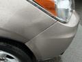 A 2016 Subaru Forester with a metallic tan exterior showing water droplets on the surface highlighting the vehicle's contours and headlight