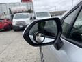 A side mirror of a 2025 Toyota Corolla showing a reflection of a vehicle in the background