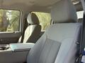 A 2015 Ford F-550 front seats with gray upholstery and a central armrest console