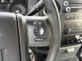 Close-up of a steering wheel control panel on a 2015 Ford F-350 featuring buttons for media, seek, and okay functions