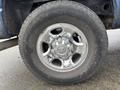 A chrome wheel with a five-spoke design mounted on a tire labeled Open Country 275/70R18 on a 2006 Dodge Ram 2500