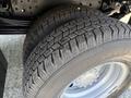 Close-up of two heavy-duty tires from a 2012 Hino 155 showcasing their tread pattern and wheel rim details