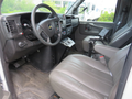Interior of a 2011 Chevrolet Express showing a driver's seat steering wheel and dashboard with various controls and instruments