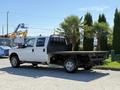 A 2012 Ford F-350 SD with a flatbed design parked facing left showing its cab and rear bed area