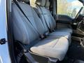 A gray interior of a 2020 Ford F-350 featuring two front seats with seat belts and fabric upholstery