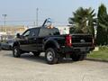 A black 2021 Ford F-350 SD truck parked with a large cargo bed and prominent wheels
