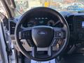 The interior of a 2019 Ford F-150 featuring a black steering wheel with controls and a dashboard displaying various gauges and a digital screen