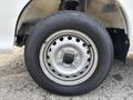 A close-up view of a silver wheel and tire from a 2010 Daihatsu Hijet with visible treads and lug nut patterns