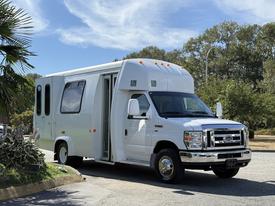 A white 2013 Ford Econoline van is parked with the side door open showcasing its spacious interior and design features