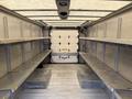 Interior of a 2012 Ford Econoline with metal shelves along the sides and a flat floor