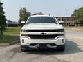 A 2017 Chevrolet Silverado 1500 in white with a prominent front grille and black accents showcasing its bold design