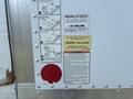A 2012 Hino 338 truck's rear side featuring liftgate operation instructions and warning labels about load capacity