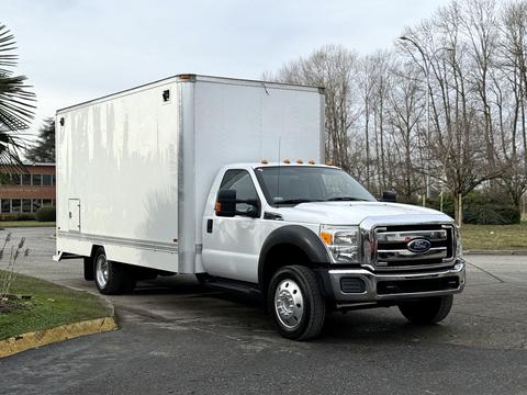 A 2012 Ford F-550 truck with a white box cargo area parked at an angle showcasing its dual rear wheels and front grille design