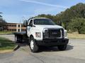 A white 2018 Ford F-750 flatbed truck with a black chassis facing forward and a distinct grille featuring the Ford logo