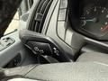 Close-up of the steering column and control lever of a 2017 Ford Transit T150 XLT showing buttons for lights and indicators