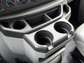A center console of a 2019 Ford Econoline featuring two cup holders and storage compartments