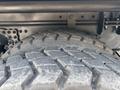 Close-up of a large tire from a 2016 Freightliner M2 106 showing deep treads and a rugged surface