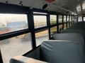 Interior view of a 2007 Freightliner B2 school bus featuring rows of gray seats and large windows looking out to other buses