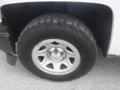 A close-up view of a tire and rim from a 2015 Chevrolet Silverado 1500 showcasing a rugged tread pattern and silver alloy wheel