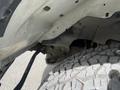 Close-up of the undercarriage of a 2022 GMC Savana showing the frame and tire tread pattern