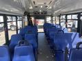 Interior of a 2020 Chevrolet Express featuring blue seats arranged in a row with aisle space and overhead lighting