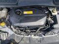 The image shows the engine compartment of a 2015 Ford Escape with a black engine cover and various components including hoses and a yellow cap