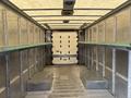 A 2018 Ford Econoline with an empty cargo area featuring metal shelving on both sides and a textured floor